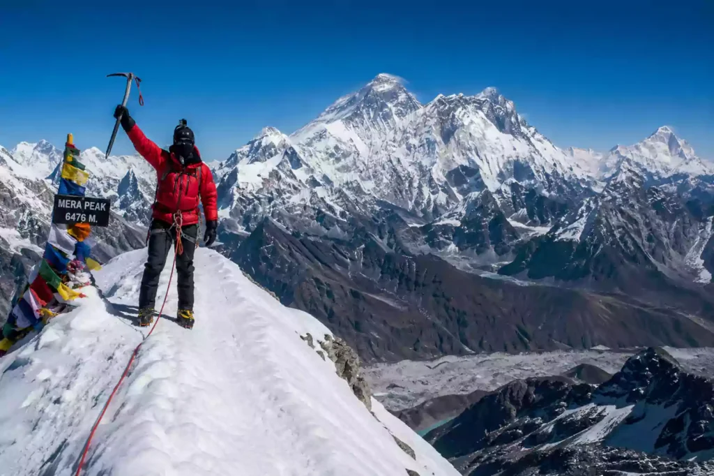 Mera Peak summit climber with Everest, Lhotse and Makalu in background – Nepal Footprint Holiday